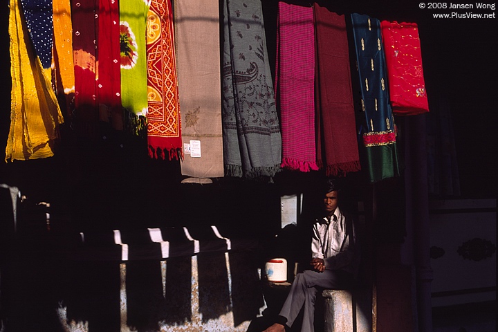 Scarf vendor sitting in his shop, Bundi