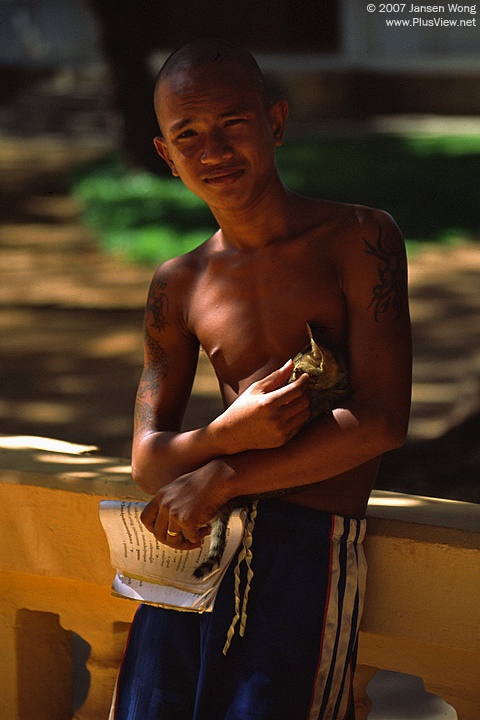 Young monk carrying cat, Wat Dam Nak, Siem Reap, Cambodia