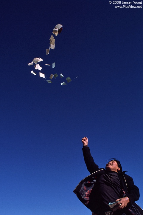 A man throwing paper Wind Horse to sky, Lhasa, Tibet