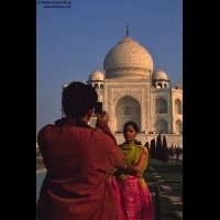 An Indian couple taking photo in front of Taj Mahal