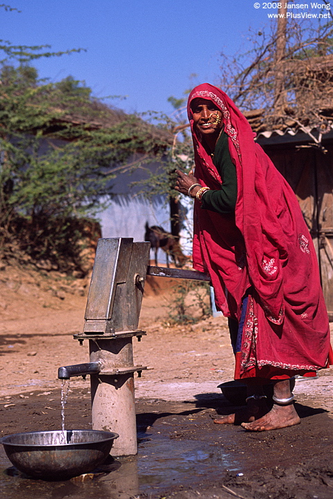 Woman pumping water from well, Akoda village