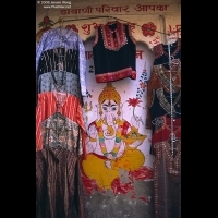 Clothes hung up  for sale against a wall of the Ganesh paintings