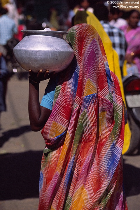 Woman carrying a pot of water