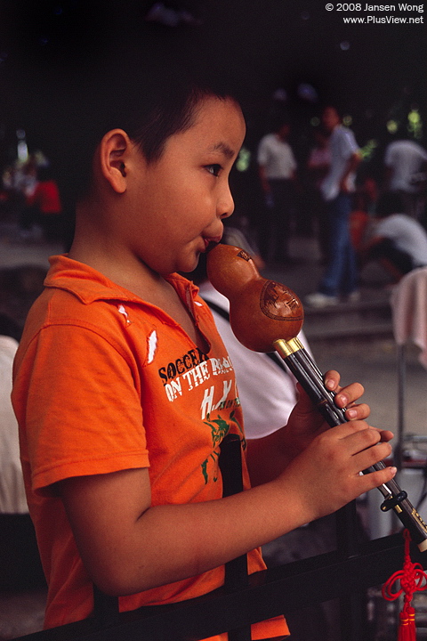 Boy playing Hulusi, Litchi Park