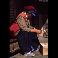 Woman cleaning Yak Butter Lamp, Deqin, Yunnan